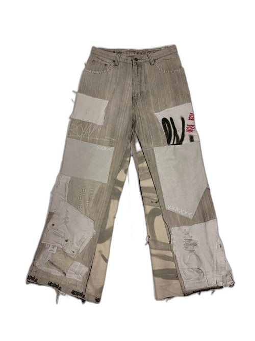 Front of deconstructed multi-patch patchwork denim pants with canvas mesh leather patches hand stitching and spray marker graffiti — one of one reconstructed upcycled streetwear Los Angeles