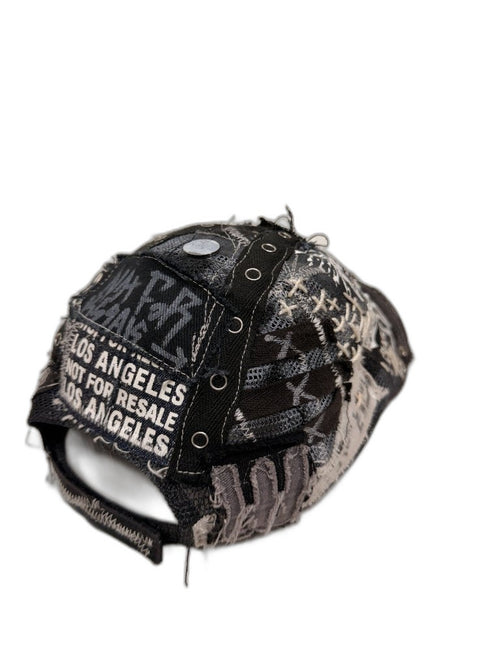 Back of black skull cap showing NFR repeating text strap X webbing straps grommets and cross stitch panels — one of one reconstructed Not For Resale Los Angeles