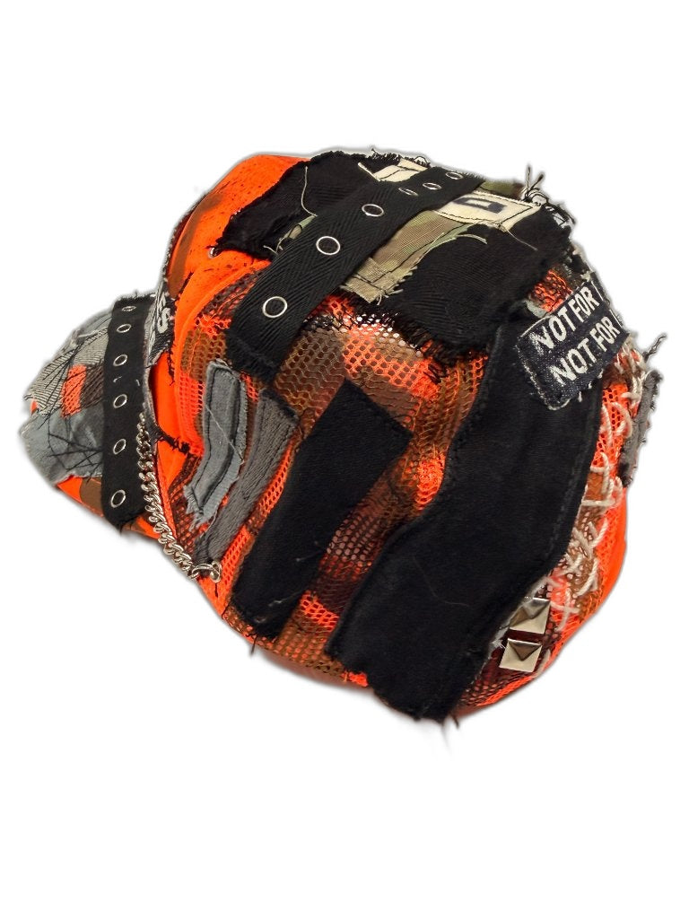 Side view of orange camo cap showing mesh panels black straps with grommets silver pyramid stud NOT FOR label and white cross lace — one of one reconstructed NFR