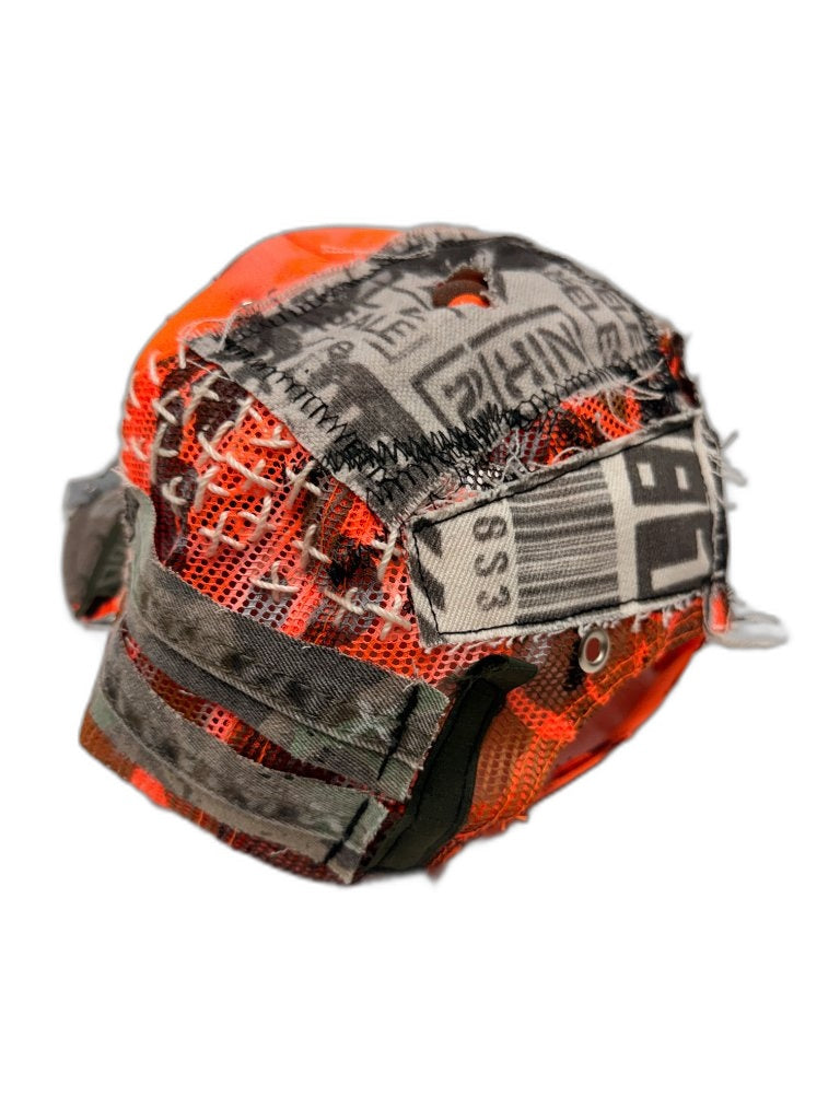 Back and crown of orange spray cap showing NFR grey print and barcode fabric panels white cross stitch lacing single grommet and grey strap — one of one upcycled NFR LA