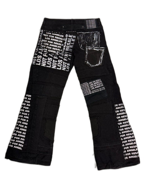 Back full view of black reconstructed flare denim showing all-over NFR LOS ANGELES screen print panels hand painted pocket outline white graphic grommet and NFR waist patch — one of one reconstructed Not For Resale