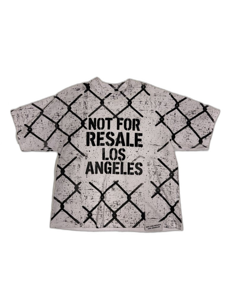 Front of white oversized tee with all-over chain-link fence screen print and bold NOT FOR RESALE LOS ANGELES center chest stencil plus NFR woven hem label — one of one reconstructed NFR LA